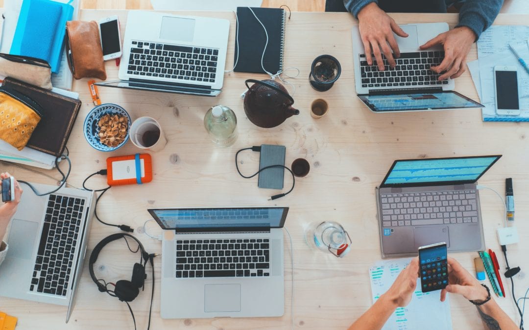 Personas utilizando sus dispositivos para crear estrategias de marketing